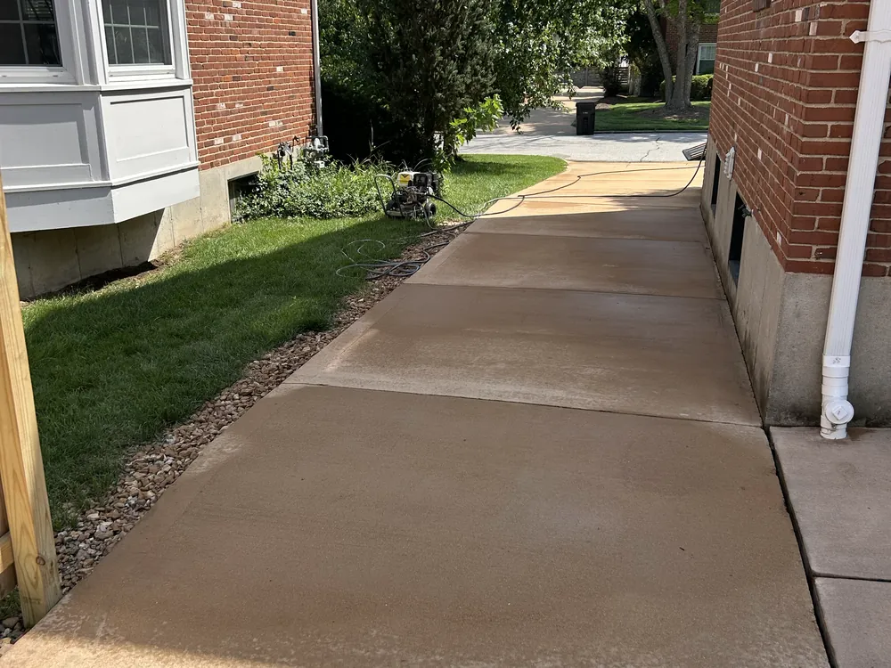 Concrete driveway restored to its original color after pressure washing